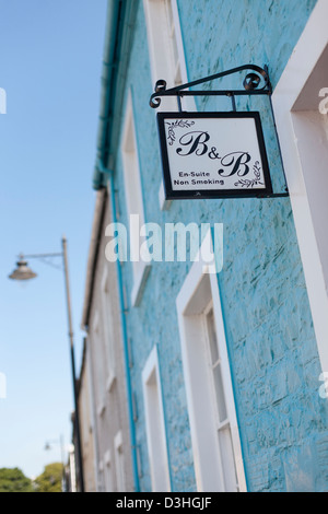 Un bed and breakfast segno appeso al di fuori di un colorfully case dipinte a Kirkcudbright, Dumfries and Galloway in Scozia Foto Stock