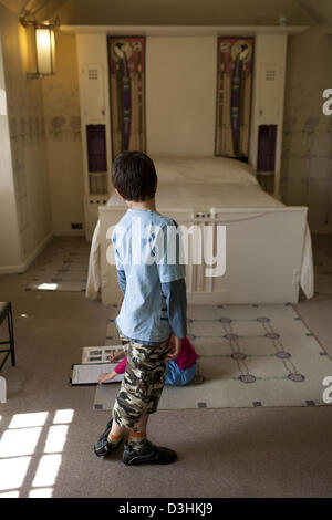Un ragazzo in una camera da letto l'Hill House progettata da Charles Rennie Mackintosh e costruito per Walter Blackie in Helensburgh, in Scozia Foto Stock