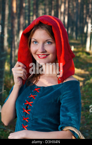 Red Riding Hood in piedi in un legno . bella ragazza in abito medievale Foto Stock