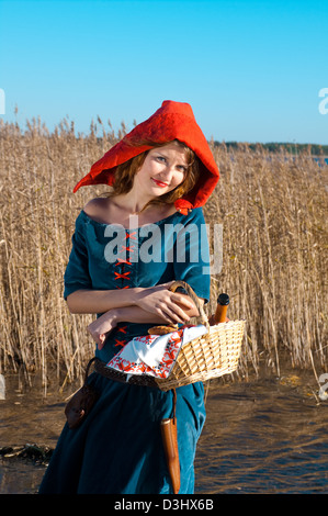 Red Riding Hood in piedi in un legno . bella ragazza in abito medievale Foto Stock