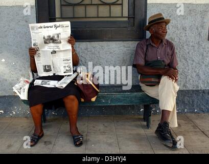 (Dpa) - Un uomo anziano si rilassa su una panchina mentre una donna sta leggendo un giornale su una panca in legno a Paramaribo, capitale del Suriname, Sud America, 26 novembre 2003. Foto Stock