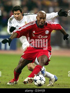 (Dpa) - Bayern Monaco di Baviera centrocampista brasiliano Ze Roberto (anteriore) corre con la palla come lui è stato attaccato da Madrid centrocampista portoghese Luis Figo durante la Champions League round di sedici partita di calcio tra FC Bayern Monaco e Real Madrid a Monaco di Baviera, Germania, il 25 febbraio 2004. Il gioco si è conclusa con un pareggio. Foto Stock