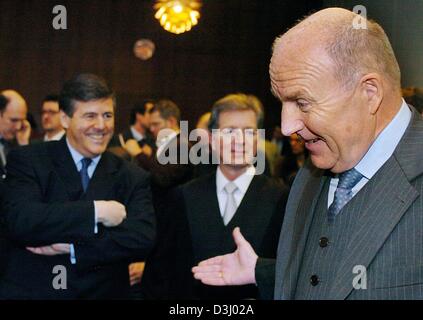 (Dpa) - Klaus Zwickel (L, anteriore), ex presidente della tedesca unione metalmeccanici IG Metall e membro del consiglio di vigilanza di Mannesmann, sorrisi come egli cammina passato Josef Ackermann (L), presidente della Deutsche Bank e il suo avvocato Klaus Volk (C) poco prima dell' inizio della cosiddetta Mannesmann processo presso il tribunale distrettuale a Duesseldorf in Germania, 21 gennaio 2004. La prova f Foto Stock