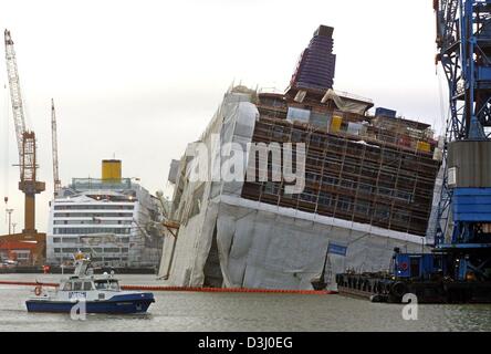 (Dpa) - La nave da crociera "Pride of America" che è ancora in corso di costruzione di elenchi su un lato nel cantiere navale Lloyd Bremerhaven, Germania settentrionale, 14 gennaio 2004. Nella notte precedente la 280 m lunga crociera del rivestimento è stata colpita da un squall, inclinandolo contro il molo. Presumibilmente è entrata acqua attraverso botole aperte in modo che la ocean liner affondò a terra del porto turistico di basi Foto Stock