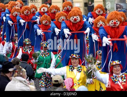 (Dpa) - Un gruppo di sciocchi di carnevale in costume portano grandi clown bambole durante il carnevale lunedì sfilata di Colonia, Germania, 23 febbraio 2004. Più di due milioni di carnevale stolti unite le processioni che sono per il momento culminante della stagione di carnevale a Colonia e Dusseldorf. Foto Stock