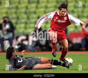 (Dpa) - Bayern Monaco di Baviera defender Bixente Lizarazu (R) e Hannover il centrocampista Nebojsa Krupnikovic lotta per la sfera durante la Bundesliga partita di calcio tra FC Bayern Monaco e Hannover 96 a Monaco di Baviera, Germania, il 8 febbraio 2004. In fine, Bayern Monaco ha vinto il gioco da parte di un cliente di 3-1 contro di Hannover. Foto Stock