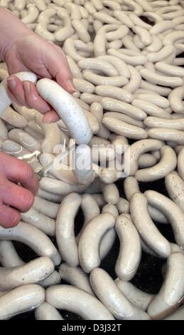 (Dpa) - un macellaio di tagli di una coppia di fresca bavarese seethed salsicce di vitello in corrispondenza di una macelleria a Augsburg, Germania, 22 gennaio 2004. La norcineria produce circa 7.000 salsicce su una base quotidiana. La città di Monaco di Baviera ha preso i lati a nome della città macellai e i padroni di casa riguardante un argomento che solo quelle bavaresi salsicce di carne di vitello, che sono prodotti di Monaco possono essere chiamati Bavarian Foto Stock