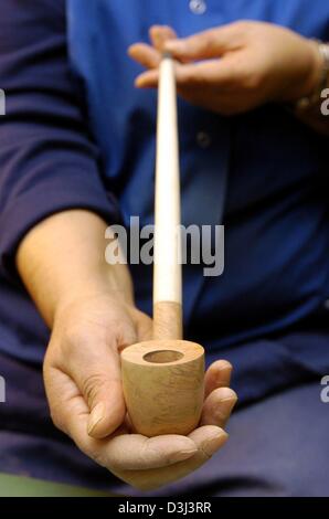 (Dpa) - Un dipendente di Vauen, produttore di tubi, presenta il 'Gandalf il Signore degli Anelli" tubo in Nuremberg, Germania, 17 dicembre 2003. Il tubo è l'ultima creazione ed era releast in tempo per l inizio del film "Il Ritorno del Re", la terza parte di Hollywood fantasy "Signore degli Anelli". Il tubo è di forma simile a quella del tubo presenti nel film un Foto Stock