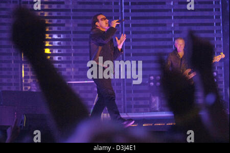 (Dpa) - Bono (C), anteriore-uomo del British rock band 'U2' e U2's bassista Adam Clayton (L, retro) eseguire durante un concerto della banda di Gelsenkirchen, Germania, Domenica, 12 giugno 2005. La band è attualmente in tour mondiale per promuovere il loro album Vertigo. Foto Stock