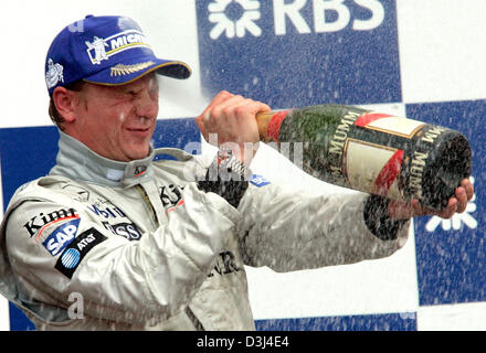 (Dpa) - Finlandese pilota di Formula Uno Kimi Raikkonen della McLaren Mercedes, sorge sul podio e spray in giro con una bottiglia di champagne dopo aver vinto il Gran Premio di Formula Uno del Canada al corso canadese Gilles Villeneuve a Montreal, Canada, Domenica, 12 giugno 2005. Raikkonen ha vinto il Grand Prix precedendo di Ferrari il pilota tedesco Michael Schumacher e il pilota brasiliano Rubens Bar Foto Stock