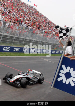 (Dpa) - Finlandese pilota di Formula Uno Kimi Raikkonen della McLaren Mercedes spinge la sua vettura da corsa attraverso la linea di finitura vincere il Gran Premio di Formula Uno del Canada al corso canadese Gilles Villeneuve a Montreal, Canada, Domenica, 12 giugno 2005. Raikkonen ha vinto il Grand Prix precedendo di Ferrari il pilota tedesco Michael Schumacher e il pilota brasiliano Rubens Barrichello. Foto Stock