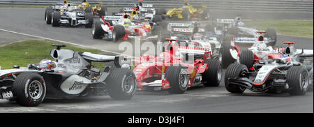 (Dpa) - l'immagine mostra colombiana per pilota di Formula Uno Juan Pablo Montoya della McLaren Mercedes (L); Tedesco pilota di Formula Uno Michael Schumacher (C) di Ferrari e il finlandese Kimi Raikkonen della McLaren Mercedes (R) fianco a fianco dopo l'inizio della F1 nel Gran Premio del Canada alla gara canadese via Gilles Villeneuve a Montreal, Canada, 12 giugno 2005. Foto Stock