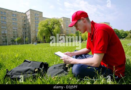 (Dpa) - Uno studente di legge le sue note come egli si siede sul prato di fronte al cosiddetto edificio Poelzig sul Westend campus dell'Università di Francoforte A Francoforte, Germania, 18 maggio 2004. I locali, che apparteneva alla ex chimico tedesco gigante-IG Farben gruppo, accoglie fin dal 2001 nel periodo estivo le arti e le discipline umanistiche dipartimenti delle università. L'edificio, chiamato dopo Foto Stock