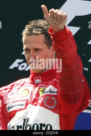 (Dpa) - tedesco di Formula Uno del campione del mondo in carica Michael Schumacher (Ferrari) cheers dopo la vittoria al Gran Premio Europeo al Nuerburgring race track in Germania, 30 maggio 2004. Foto Stock