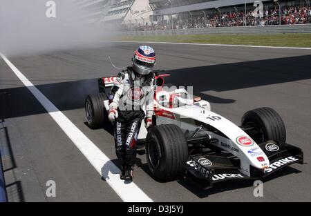 (Dpa) - Giapponese pilota di Formula Uno di Takuma Sato abbandona il suo BAR-Honda racing car dopo un guasto del motore durante la European F1 Grand Prix al Nurburgring race track, Germania, 30 maggio 2004. Foto Stock