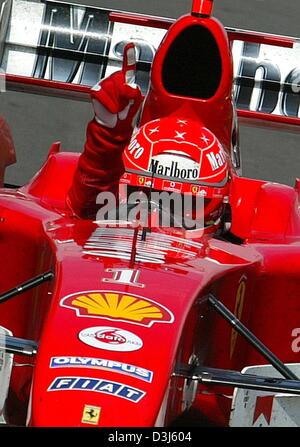 (Dpa) - tedesco di Formula Uno del campione del mondo in carica Michael Schumacher (Ferrari) cheers dopo la vittoria al Gran Premio Europeo al Nuerburgring race track in Germania, 30 maggio 2004. Foto Stock