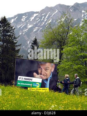 (Dpa) - Due escursionisti guardare il più alto in base Cartellone elettorale per le elezioni europee su un prato in Oberjoch, Germania, 1 giugno 2004. Il poster raffigura il Ministro degli esteri tedesco Joschka Fischer del Partito Verde puntando verso la scritta 'Yourope - decidete voi'. Secondo il partito dei Verdi il poster, che è situato ad un altitudine di oltre 1300 metri, è il più alto di ba Foto Stock