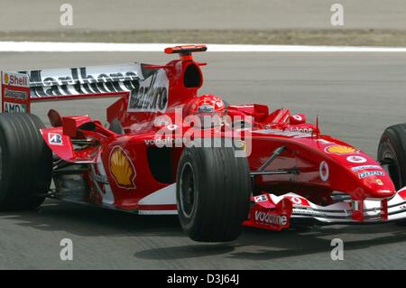 (Dpa) - tedesco di formula one champion Michael Schumacher velocità nella sua Ferrari racing car durante la seconda formazione gratuita al Nuerburgring race track in Germania, Venerdì, 28 maggio 2004. Schumacher ha guidato il nono tempo più veloce. Il Grand Prix Europeo avviene al Nuerburgring il 30 giugno 2004. Foto Stock