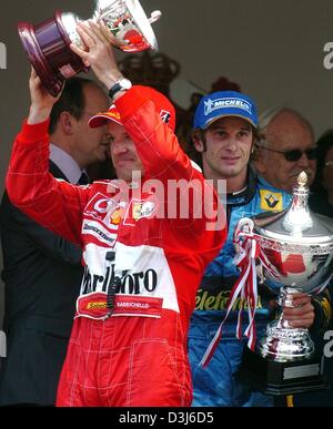 (Dpa) - Italiano pilota di formula uno Jarno Trulli (L) della Renault sta con il suo trofeo accanto al brasiliano pilota di Formula Uno Rubens Barrichello di Ferrari, che rallegra con il suo trofeo dopo il Gran Premio di Formula 1 di Monaco, 23 maggio 2004. Trulli, che hanno iniziato la pole-position, ha celebrato la prima vittoria della sua carriera. Barrichello ha colto un terzo posto. Foto Stock