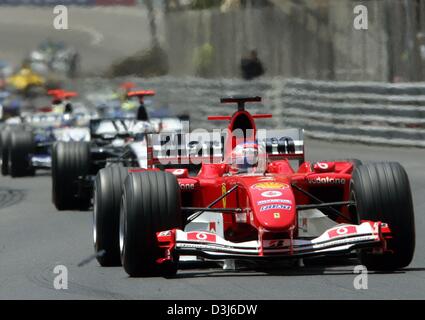 (Dpa) - Brasiliano pilota di Formula Uno Rubens Barrichello (anteriore) velocità con la sua Ferrari racing car lungo il corso della città durante il Grand Prix di Formula 1 di Monaco, 23 maggio 2004. Barrichello ha preso il secondo posto alle spalle di Jenson Button e di Jarno Trulli, che ha vinto il primo posto. Foto Stock