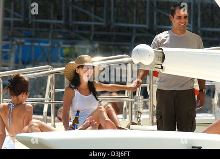 (Dpa) - colombiano di pilota di Formula Uno Juan Pablo Montoya (R) della BMW sorrisi come egli tiene per mano con la moglie Connie su uno yacht mentre godendo una giornata nel porto di Monaco, 21 maggio 2004. Il Grand Prix di Formula 1 di Monaco si terrà domenica 23 maggio 2004. Foto Stock