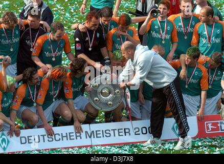 (Dpa) - Brema allenatore di calcio Thomas Schaaf mani la Bundesliga tedesca trofeo per i suoi giocatori per una foto di gruppo dopo la Bundesliga soccer game contrapposta SV Werder Brema e Bayer 04 Leverkusen in Bremen, Germania, 15 maggio 2004. Brema aveva già fissato la Bundesliga 2003/2004 titolo di campione nel gioco del calcio contro il Bayern Monaco di Baviera due giorni prima della fine dell'Bundeslig Foto Stock