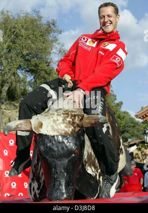 (Dpa) - Tedesco pilota di Formula uno e il campione del mondo Michael Schumacher della Ferrari cavalca un toro meccanico vicino al circuito di formula uno di Barcellona, in Spagna, il 6 maggio 2004. Il gran premio di Spagna si terrà questo fine settimana del 8 maggio e del 9 maggio 2004. Foto Stock