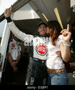 (Dpa) - inglese pilota di Formula Uno Jenson Button (Team BAR-Honda) sorrisi e riceve un bacio dalla sua amica Louise Griffiths (R) dopo la conquista la sua prima pole position di sempre al Gran Premio di San Marino di Imola, Italia, 24 aprile 2004. Egli sarebbe terminare la gara in seconda posizione dopo un giorno. Foto Stock