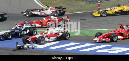 (Dpa) - Australian Formula One driver Mark Webber di BMW-Williams, tedesco Ralf Schumacher di Toyota e suo fratello Michael Schumacher della Ferrari (FRONT L-R) e molte altre vetture sono coinvolti nell'incidente dopo la partenza del Gran Premio d'Europa presso il Gran Premio di Germania via Nuerburgring in Nuerburg, Germania, 29 maggio 2005. Foto Stock