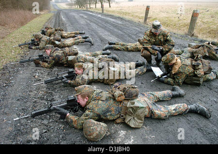 (Dpa) - maschio e femmina reclute della Bundeswehr tedesca con le pistole del G 36 tipo duck durante una pattuglia su una strada in corrispondenza di una zona di formazione di Ahlen, Germania, 18 marzo 2005. All'interno della formazione di base i soldati ricevano la formazione di distribuzione per la prevenzione dei conflitti e di far fronte a situazioni di crisi, che è per la preparazione delle reclute' distribuzione per paesi stranieri. Foto Stock