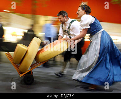 (Dpa) - latte bavarese princess Veronika Steinberger e un uomo che ha fretta di consegnare le forniture per il contatore di formaggio mentre indossa tradizionali bavaresi indumenti durante il settantesimo International alla Settimana verde di Berlino, Germania, 23 gennaio 2005. Durante i primi tre giorni della fiera più di centomila persone hanno visitato l'evento. La più grande fiera mondiale di settore alimentare, agricolo una Foto Stock