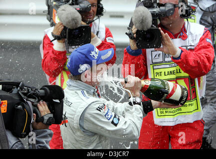 (Dpa) - Finlandese pilota di Formula Uno Kimi Raikkonen della McLaren Mercedes spruzza champagne dopo la sua vittoria al Gran Premio di Monaco a Montecarlo, Monaco, domenica 22 maggio 2005. Foto Stock