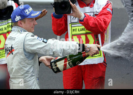 (Dpa) - Finlandese pilota di Formula Uno Kimi Raikkonen della McLaren Mercedes spruzza champagne dopo la sua vittoria al Gran Premio di Monaco a Montecarlo, Monaco, domenica 22 maggio 2005. Foto Stock