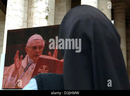 (Dpa) - una suora orologi su uno schermo video Papa Benedetto XVI il primo servizio divino a Piazza San Pietro a Roma, Italia, 20 aprile 2005. Il Cardinale Joseph Ratzinger di Germania fu eletto Papa in Vaticano martedì 19 aprile 2005 alla fine di uno dei conclavi più breve nella storia, assumendo il nome di Benedetto XVI. Foto Stock