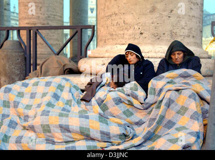 (Dpa) - Un gruppo di pellegrini sono coperti nelle coperte come dormono accanto a una colonna in piazza San Pietro durante le prime ore del mattino a Roma, Italia, 06 aprile 2005. La Basilica di San Pietro rimarrà aperta fino a venerdì 08 aprile 2005 per persone in lutto, pellegrini e visitatori provenienti da tutto il mondo che vogliono pagare il loro ultimo omaggio a Papa Giovanni Paolo II prima è prevista per il resto. Foto Stock