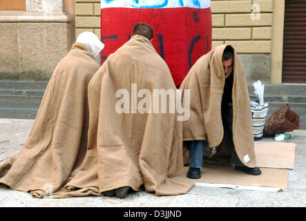 (Dpa) - Un gruppo di credenti, coperto di coperte, inginocchiati sul suolo e pregare accanto a una colonna in piazza San Pietro durante le prime ore del mattino a Roma, Italia, 06 aprile 2005. La Basilica di San Pietro rimarrà aperta fino a venerdì 08 aprile 2005 per persone in lutto, pellegrini e visitatori provenienti da tutto il mondo che vogliono pagare il loro ultimo omaggio a Papa Giovanni Paolo II prima è prevista per il resto. Foto Stock