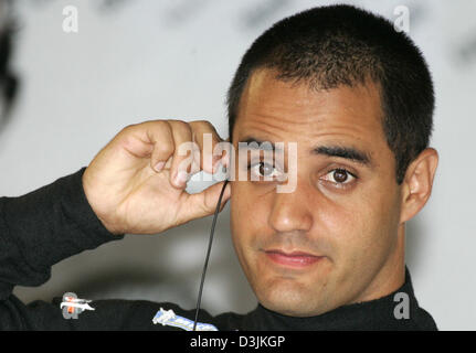 (Dpa) - Columbian pilota di Formula Uno Juan Pablo Montoya (McLaren Mercedes) mette sul suo auricolare nella fossa durante la terza sessione di formazione presso il Gran Premio della Malesia circuito di Sepang, vicino a Kuala Lumpur, Malesia, 19 marzo 2005. Il Gran Premio della Malesia ha avuto luogo il 20 marzo 2005. Foto Stock