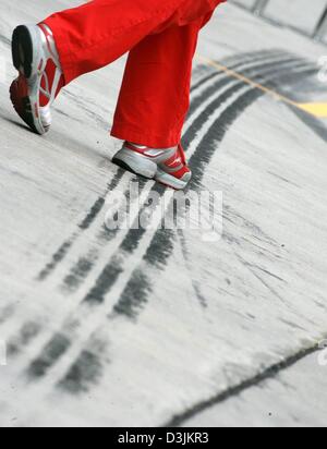 (Dpa) - Una Ferrari meccanico passeggiate su un skidmark nella pitlane presso il Gran Premio della Malesia circuito, 16 marzo 2005 a Sepang vicino a Kuala Lumpur, Malesia. Il Gran Premio della Malesia ha luogo domenica 20 marzo 2005. Foto Stock