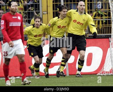 (Dpa) - (R) Dortmund i giocatori di Jan KOLLER, Ebi SMOLAREK e Lars Ricken allegria, mentre Mainz player Antonio da Silva (L) cammina davanti a loro, dopo Smolarek ha segnato il 1-0 obiettivo di piombo nella Bundesliga partita di calcio tra Borussia Dortmund e FSV Mainz 05 a Dortmund, Germania, il 26 febbraio 2005. Foto Stock