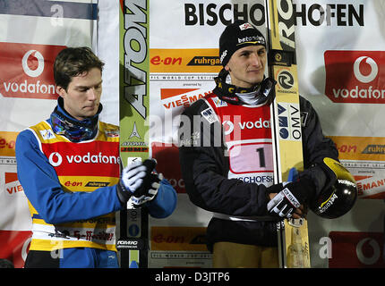 (Dpa) - finlandese ponticello sci Janne Ahonen (L) guarda disappointedly sul pavimento mentre in piedi accanto a Austrian Martin Hoellwarth durante la 53a internazionale di quattro colli nel torneo di Bischofshofen, Austria, 6 gennaio 2005. Hoellwarth ha vinto la fase finale di ski-jumping quattro colli Tour e negato il campione globale Janne Ahonen un raro Grand Slam. Foto Stock