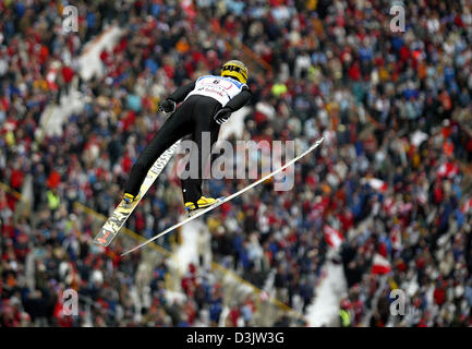 (Dpa) - Austrian ski jumper Martin Hoellwarth salta di fronte a una grande folla nella terza gamba della 53 International quattro colli nel torneo di Innsbruck, Austria, lunedì 3 gennaio 2005. Foto Stock