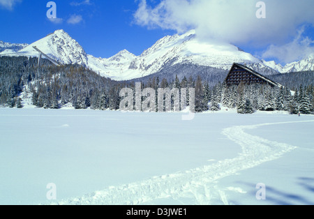Percorso turistico su congelato e coperta di neve tarn villaggio di Strbske Pleso, Alti Tatra, Slovacchia. Foto Stock