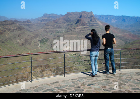 Coppia giovane guardando fuori sopra le montagne a Degollada de las Yeguas Gran Canaria Foto Stock