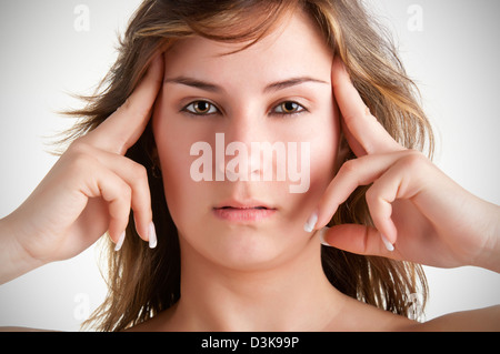 La donna che soffre di un mal di testa, tenendo le mani alla testa Foto Stock