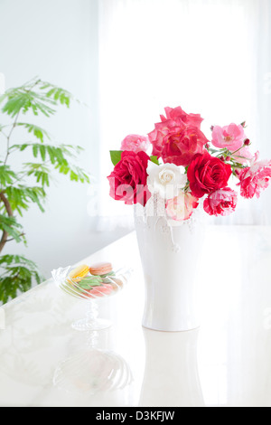 Le Rose in un vaso e amaretti Foto Stock