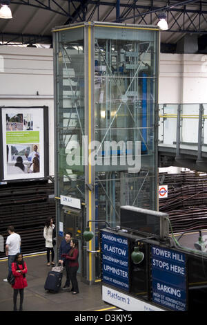Sollevare per prendere i passeggeri a piattaforma, & i passeggeri in attesa per i treni della metropolitana di Londra / metropolitana alla stazione di Earls Court Regno Unito Foto Stock