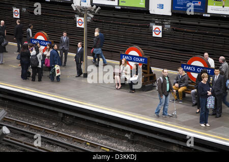 Piattaforma con i passeggeri in attesa per i treni della metropolitana di Londra / metropolitana alla stazione di Earls Court. Regno Unito Foto Stock