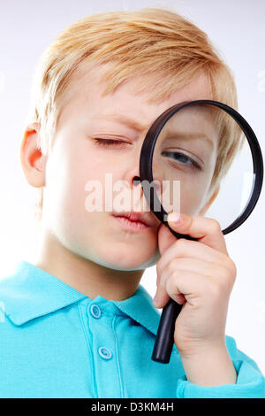 Ritratto di un bambino guardando attraverso la lente di ingrandimento Foto Stock