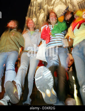 (Dpa) - Giovani pellegrini celebrare durante la XX Giornata Mondiale della Gioventù di fronte alla cattedrale di Colonia, Germania, 18 agosto 2005. In retro mostra un banner il ritratto di Papa Benedetto XVI. Circa un milione di giovani provenienti da 193 paesi sono attesi per la XX Giornata Mondiale della Gioventù a Colonia fino al 21 agosto 2005. Foto: Patrick Seeger Foto Stock