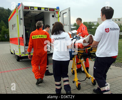 (Dpa) - membro di equipaggio di Salvataggio in elicottero "Christoph 27' dal tedesco Air Rescue (DRF) stazione di Norimberga il medico del pronto soccorso Walter Weber (L) e quattro altri lifesavers trasporti un uomo ferito da una croce rossa van vicino a Norimberga, Germania, 29 luglio 2005. Foto: Patrick Seeger Foto Stock